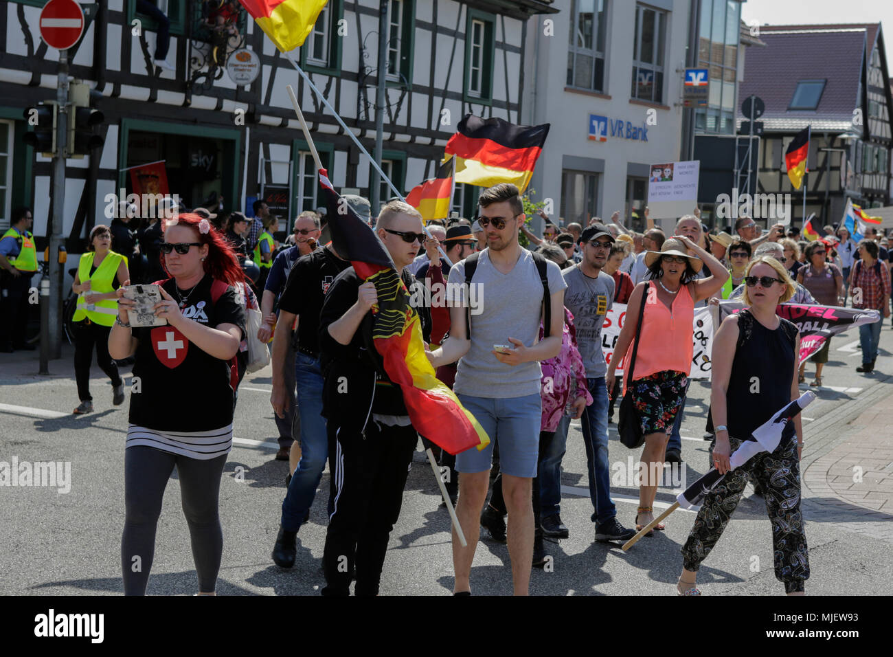 Kandel, Allemagne. 5 mai 2018. Les manifestants de droite mars avec bannières et drapeaux allemands grâce à Kandel. Autour de 300 personnes des organisations d'extrême droite ont protesté dans la ville de Kandel en Palatinat, contre les réfugiés, les étrangers et le gouvernement allemand. Le lieu de la manifestation a été choisi en raison de l'attaque, 2017 Kandel poignardant dans lequel une jeune fille de 15 ans a été tué par un demandeur d'asile. Ils ont été harcelés par des anti-fasciste autour de 200 contre-manifestants de différents partis politiques et société Crédit : Michael Debets/Alamy Live News Banque D'Images