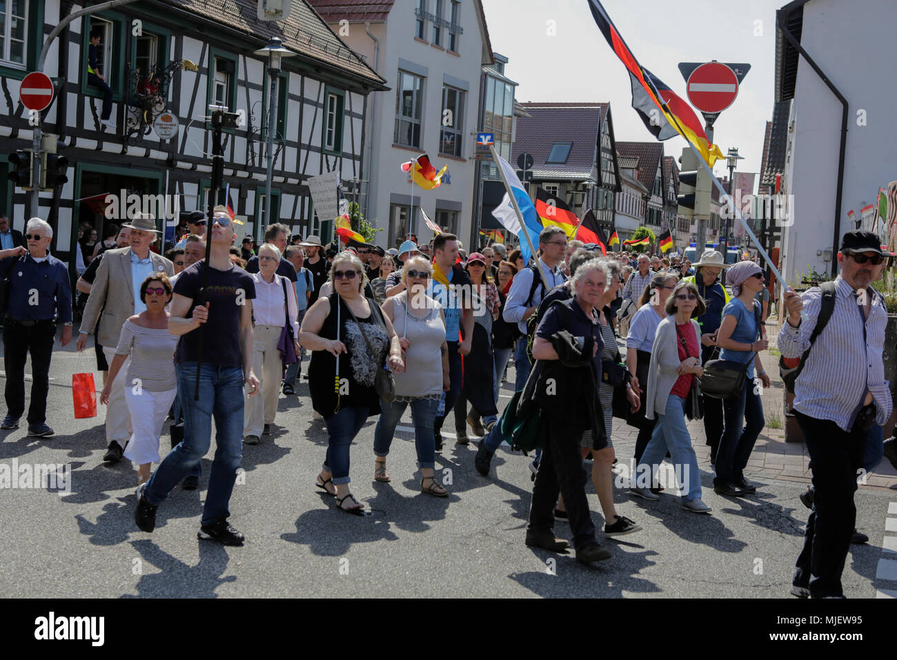 Kandel, Allemagne. 5 mai 2018. Les manifestants de droite mars avec bannières et drapeaux allemands grâce à Kandel. Autour de 300 personnes des organisations d'extrême droite ont protesté dans la ville de Kandel en Palatinat, contre les réfugiés, les étrangers et le gouvernement allemand. Le lieu de la manifestation a été choisi en raison de l'attaque, 2017 Kandel poignardant dans lequel une jeune fille de 15 ans a été tué par un demandeur d'asile. Ils ont été harcelés par des anti-fasciste autour de 200 contre-manifestants de différents partis politiques et société Crédit : Michael Debets/Alamy Live News Banque D'Images