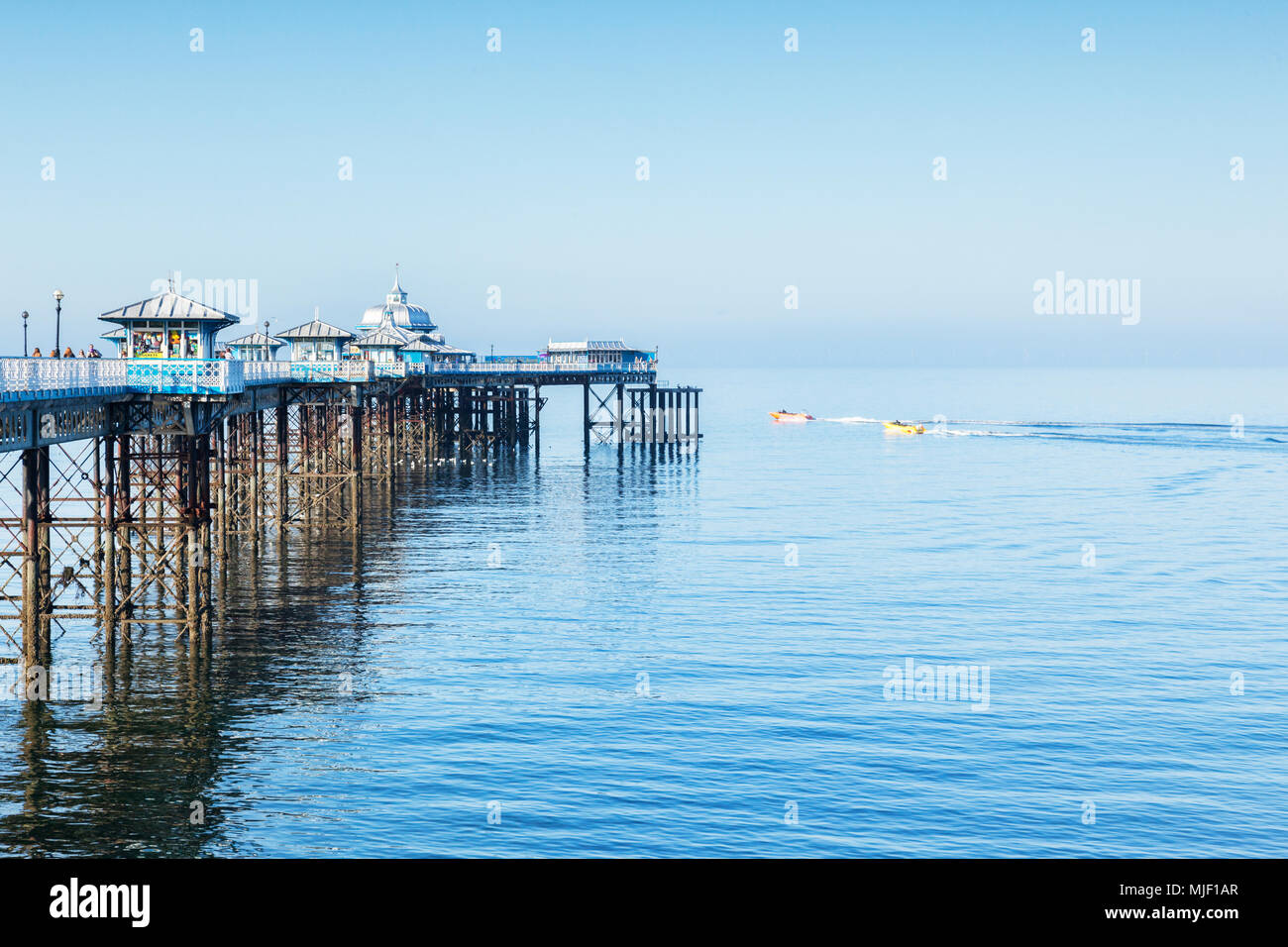 Llandudno, Nord du Pays de Galles, Royaume-Uni, 5 mai 2018. La jetée avec mer bleue et le ciel et le soleil le jour de semaine Banque D'Images