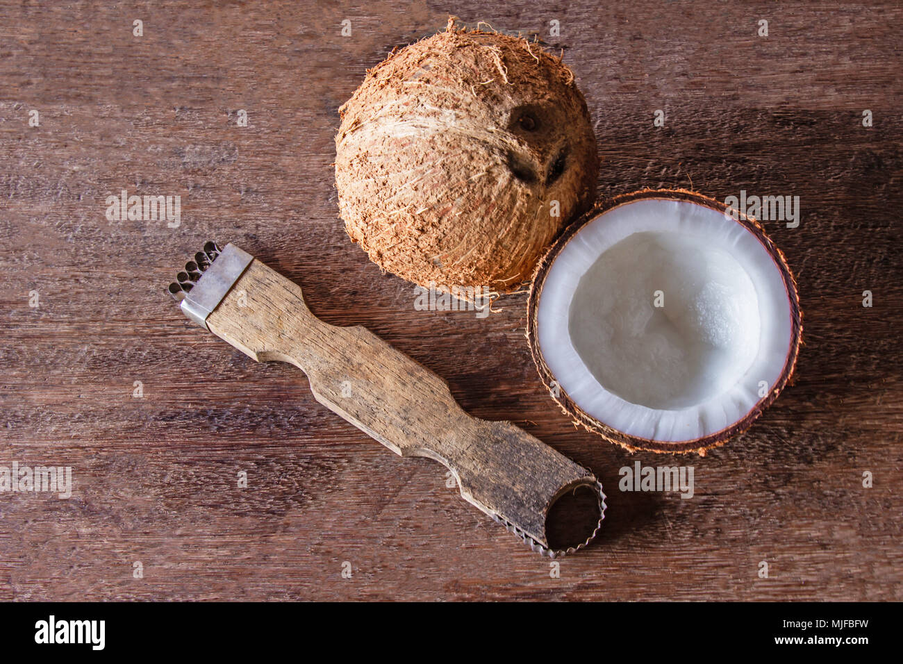 L'outil pour racler la chair de noix de coco Petit sur plancher de bois. Vue d'en haut Banque D'Images