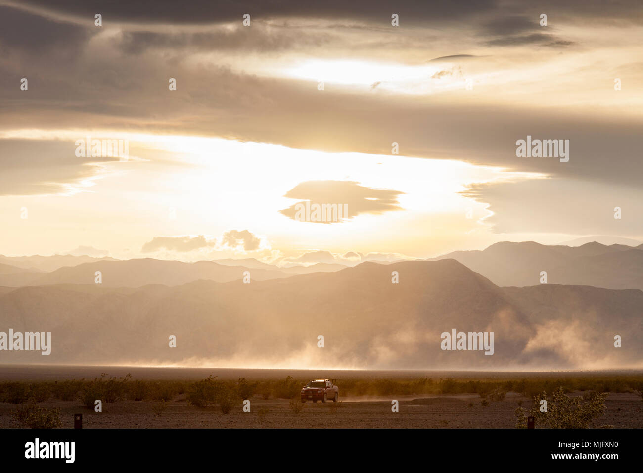 4X4 véhicule roulant sur la vallée de la mort, Californie, sous un ciel dramatique. Banque D'Images