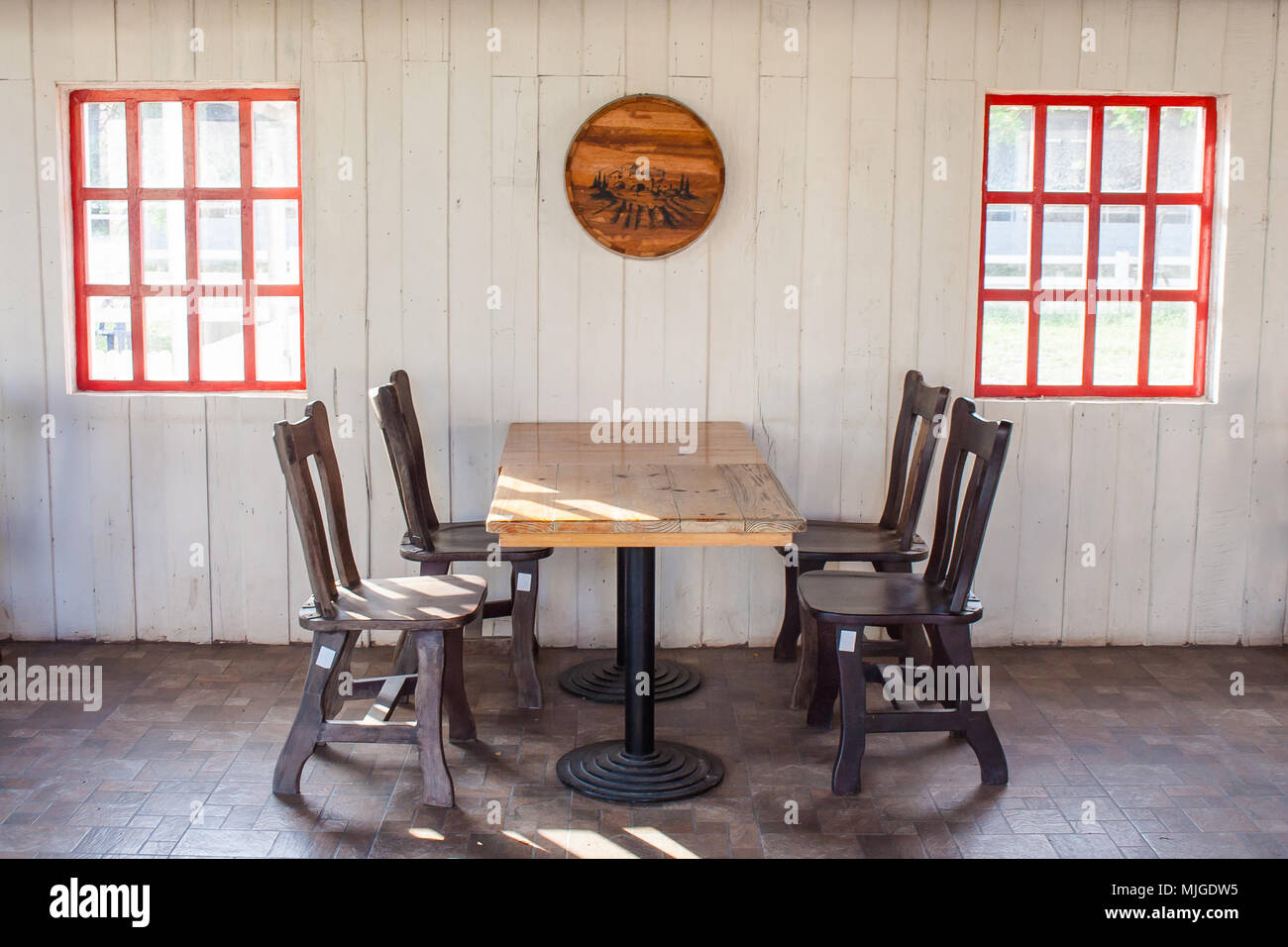 Vieille table et chaises en bois décorer en restaurant avec fenêtre rouge sur le mur blanc en arrière-plan. Banque D'Images