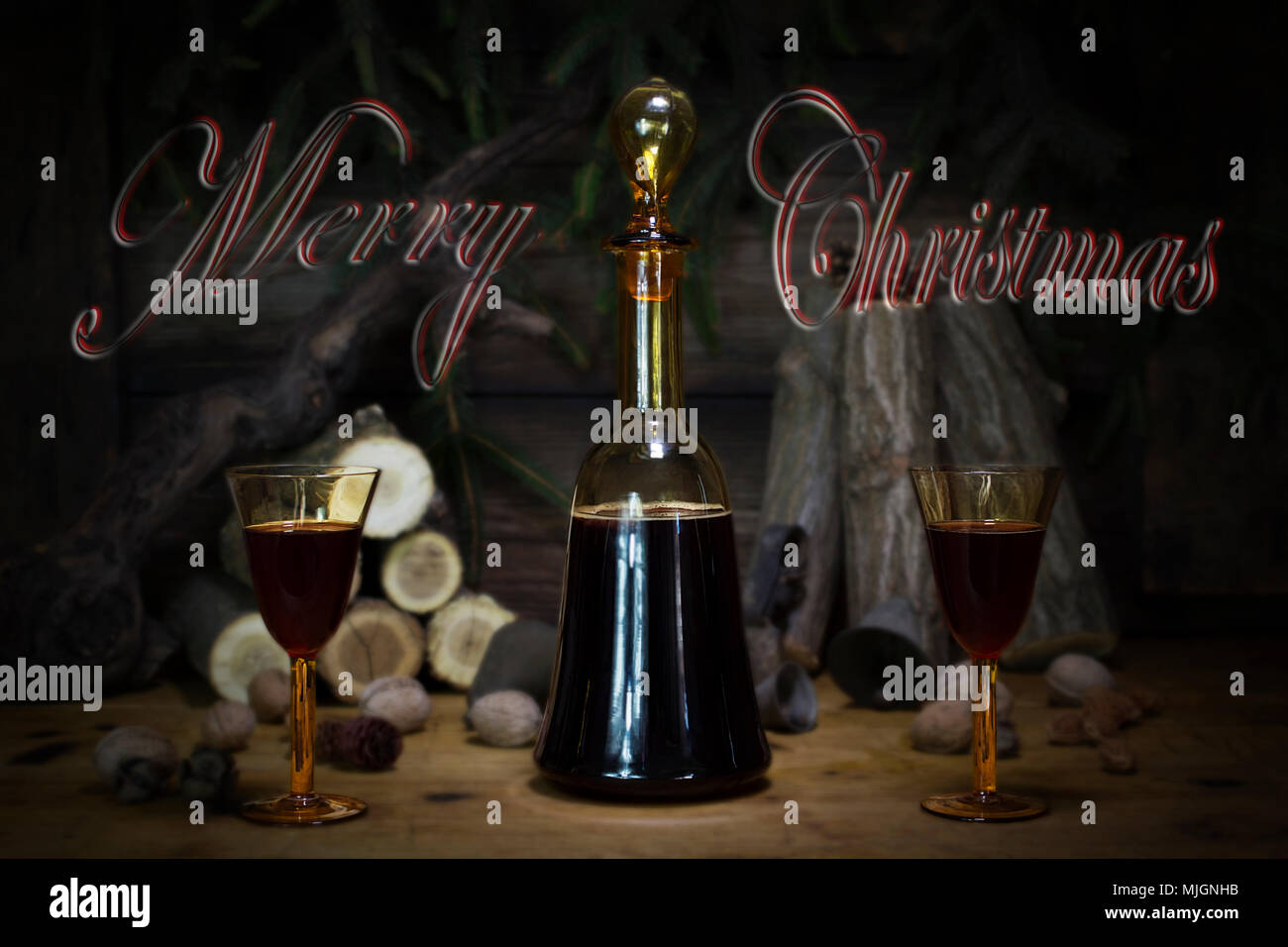 Joyeux Noël signe avec Red Wine Vintage bouteille et verres en appui sur table en bois avec Stardust et flocons de neige dans l'arrière-plan Banque D'Images