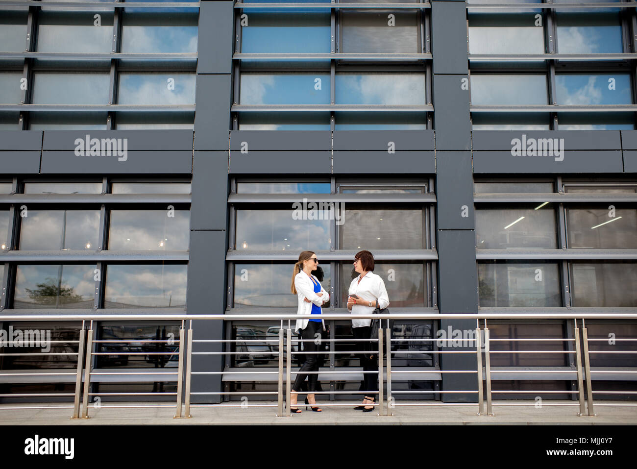 Les gens d'affaires, debout près de la façade moderne Contexte Banque D'Images