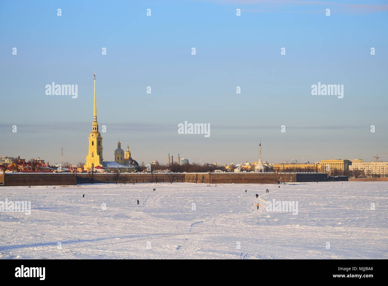 Les gens marchent sur la glace de la rivière Neva en face de la forteresse Pierre et Paul sur une journée ensoleillée à Saint-Pétersbourg Banque D'Images