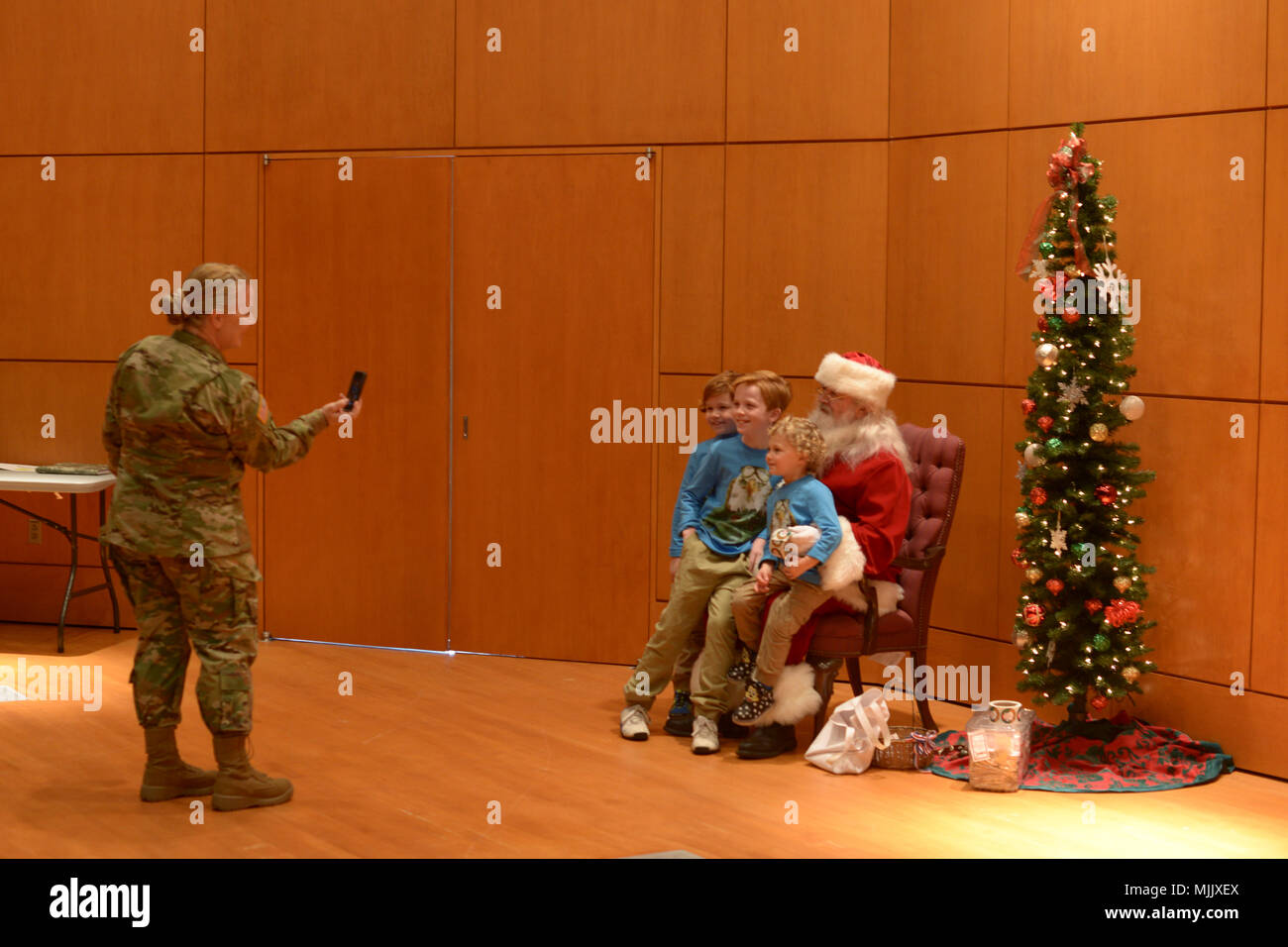 Le Lieutenant-colonel de l'Armée de Michele Harper, un officier de l'aviation de l'Armée de l'État, prend une photo de ses enfants assis avec le Père Noël au Siège et de l'Administration centrale, du Détachement de la Force conjointe de l'Administration centrale (Partie à Raleigh (Caroline du Nord), le 3 décembre 2017. Les soldats et leurs familles ont passé la journée à visiter avec le Père Noël, en maison de l'artisanat, regardant l'USO Show Troupe, l'écoute de la bande armée 440e et profiter de vacances repas ensemble. (U.S. Photo de la Garde nationale par le sergent. Mary Junell, 382e Détachement des affaires publiques/libérés) Banque D'Images