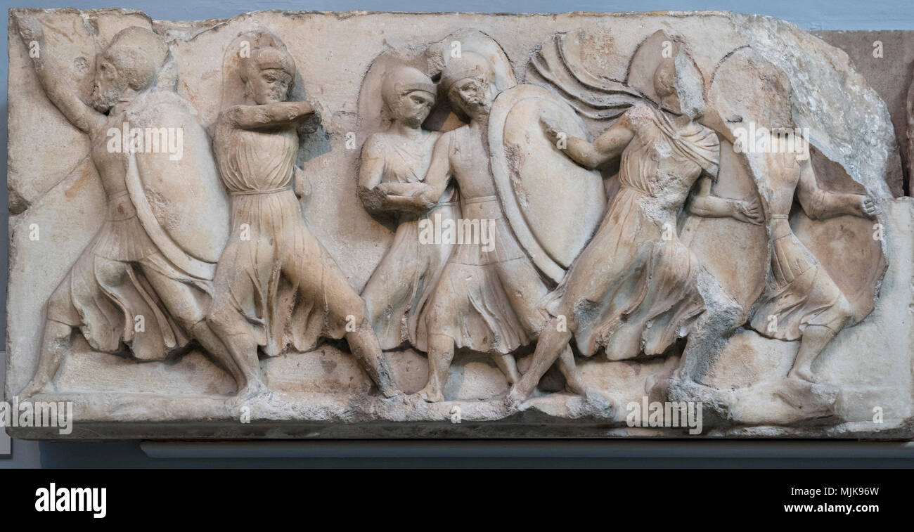 Londres. L'Angleterre. British Museum, Monument néréide, frise (détail), un archer tire son arc, tandis qu'un soldat blessé est aidé sur le terrain par ses co Banque D'Images