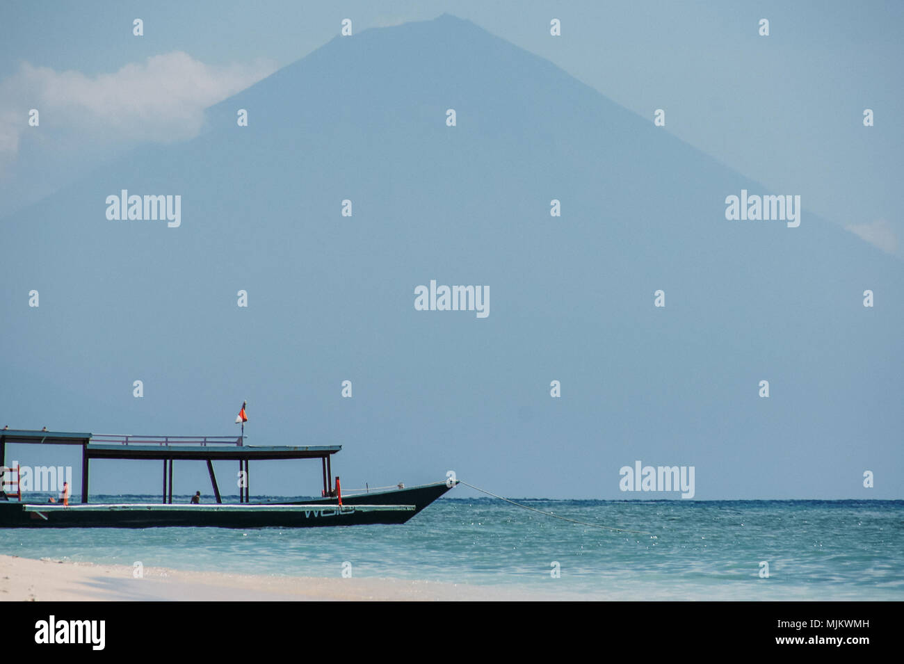 Plaisir bateau amarré sur une plage de sable de fond de montagne Banque D'Images