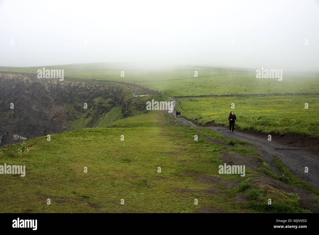 Les femmes en marche par les Falaises de Moher en Irlande Banque D'Images