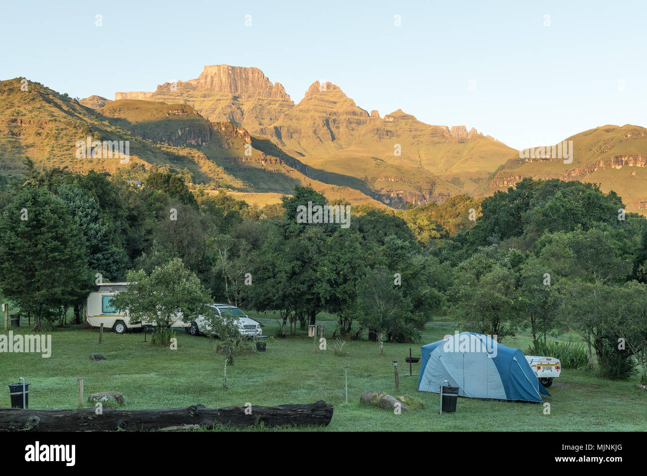 MONKS COWL, AFRIQUE DU SUD - le 18 mars 2018 : une tente, caravane et du véhicule sur le camping au bord de moines dans le Drakensberg. Cathedral Peak (à gauche) et Banque D'Images