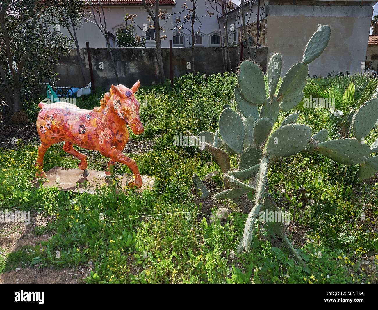 L'orange vif du carrousel parmi les taillis de cactus, de la vieille ville de Jaffa, en Israël, une peinture moderne pour la décoration intérieure. Banque D'Images