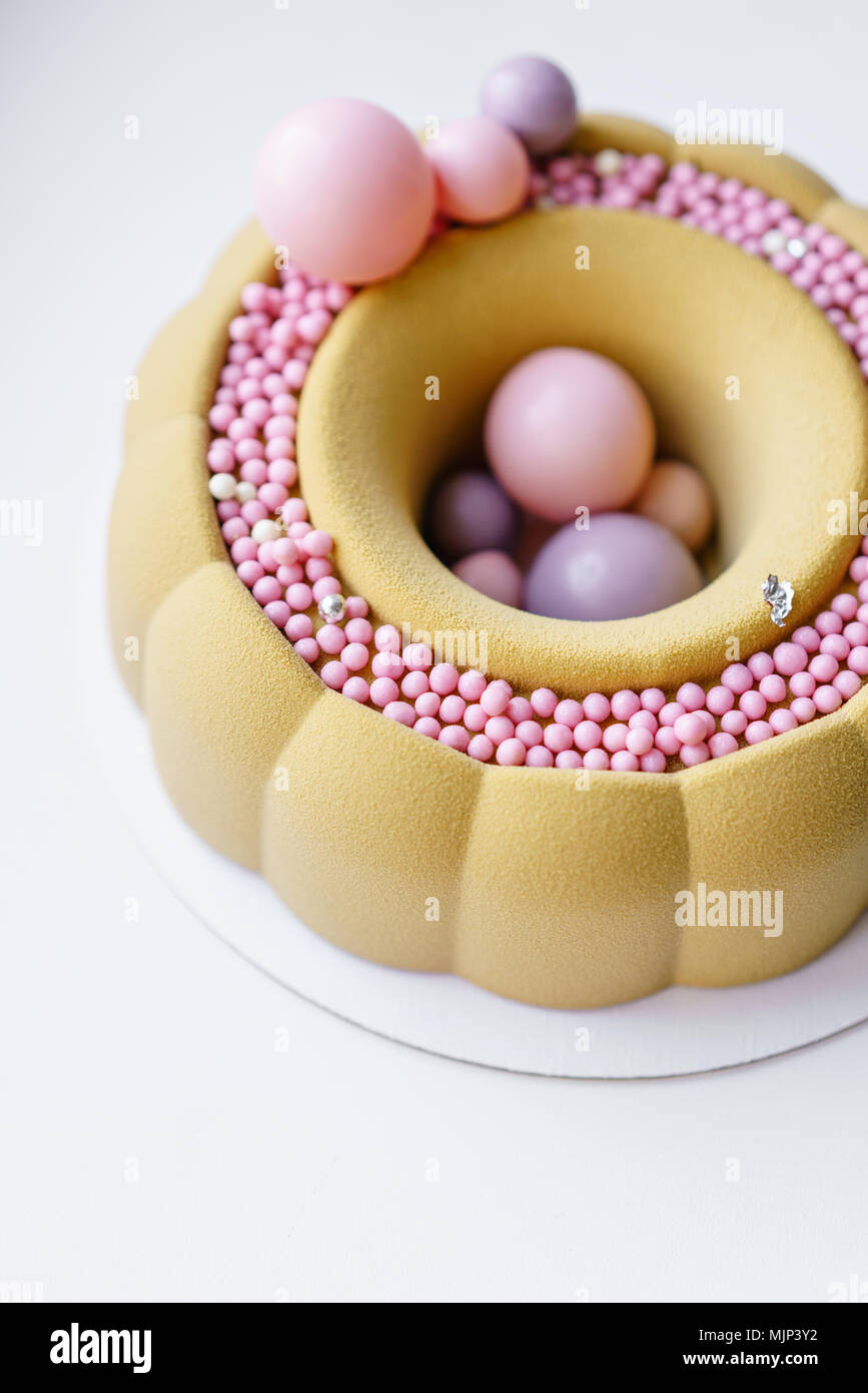 Tour de Luxe avec dessert chocolat rose. Gâteau d'anniversaire mousse jaune multicolore doux avec des boules de sucre. Petites boules. Banque D'Images