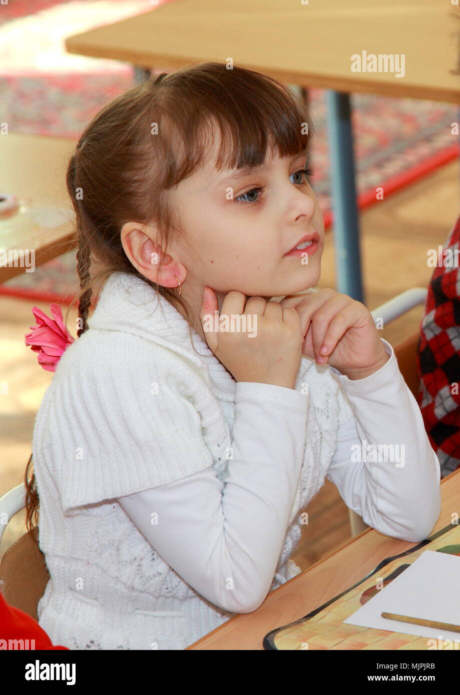 Preschool girl Cute assis à une petite table dans une chambre ensoleillée. Leçon de dessin en maternelle. Banque D'Images