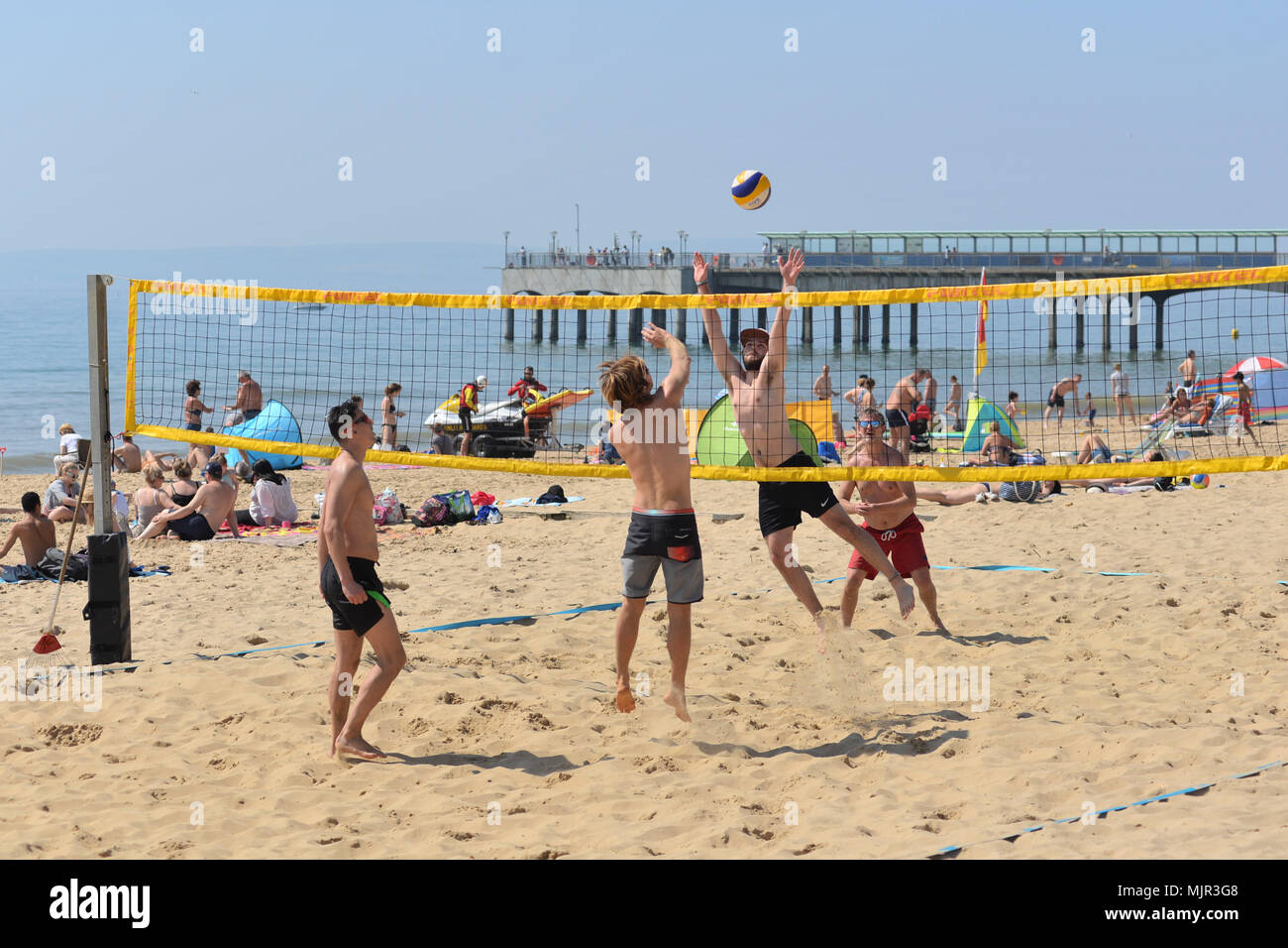 , Boscombe Bournemouth, Dorset, UK, 6 mai 2018, la météo : soleil du matin sur la côte sud sur ce qui pourrait être le plus chaud de l'appel Mayday bank holiday weekend sur dossier. Les jeunes hommes à jouer au volleyball de plage en parfaite condition. Banque D'Images