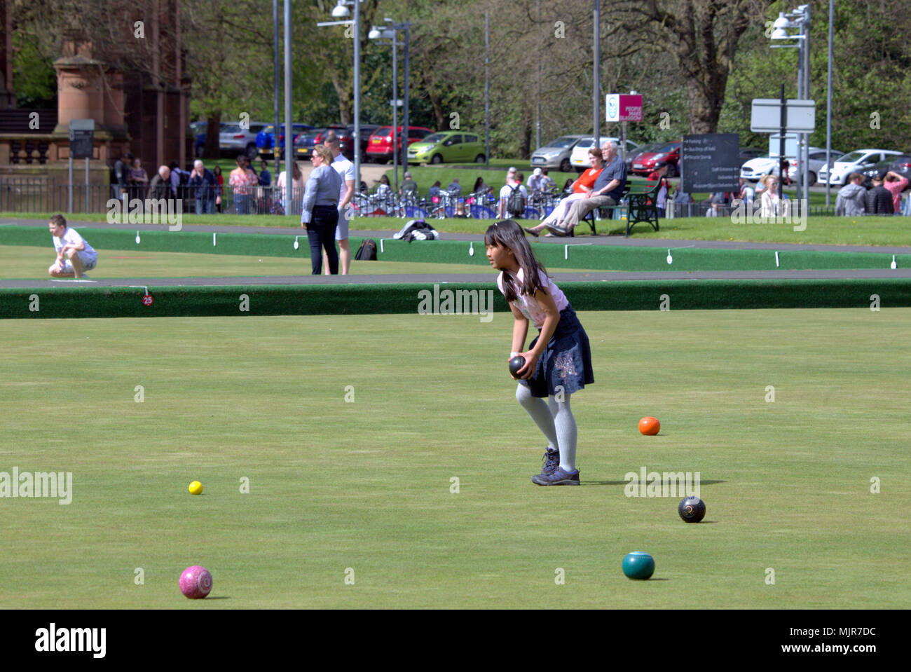 Glasgow, Écosse, Royaume-Uni le 6 mai. Météo France : little girl playing bowls Sunny summer weather atteint enfin la ville pour le week-end férié. Les habitants et les touristes de profiter du soleil dans le parc Kelvingrove Boulingrin et Kelvingrove Tennis Center dans le somptueux extrémité ouest de la ville. Gérard Ferry/Alamy news Banque D'Images