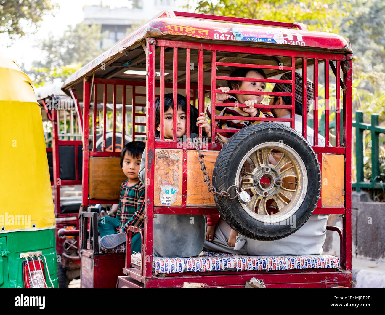 New Delhi, Inde, 20 février, 2018 - Les enfants de regarder par l'arrière d'un tuk-tuk via la grille Banque D'Images