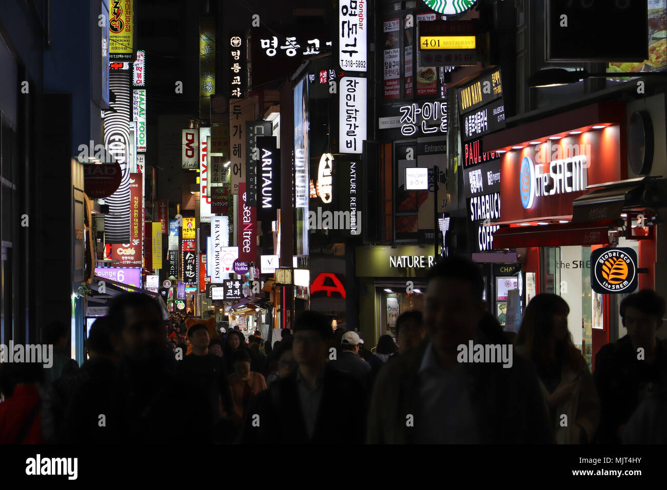 Les gens affluent à l'animation de la zone Myeongdong de Séoul, Corée du Sud, dans la soirée pour faire des achats, de l'alimentation de rue de l'échantillon, vérifier les modes, les tendances. La foule dense. Banque D'Images