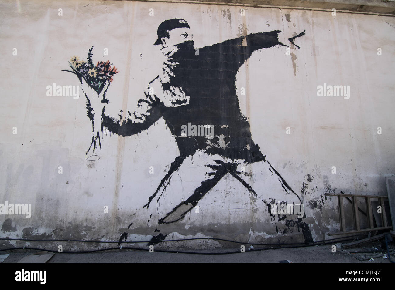 La célèbre fresque de Banksy 'rage, le lanceur de fleurs (l'amour est dans l'air)' qui est peinte sur un lavage de voiture dans une banlieue de Betlehem (Palestine) Banque D'Images