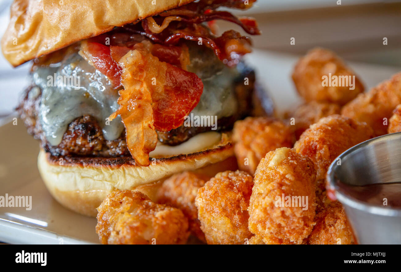 Bouffées de pommes de terre avec un bacon Cheeseburger dans l'arrière-plan Banque D'Images