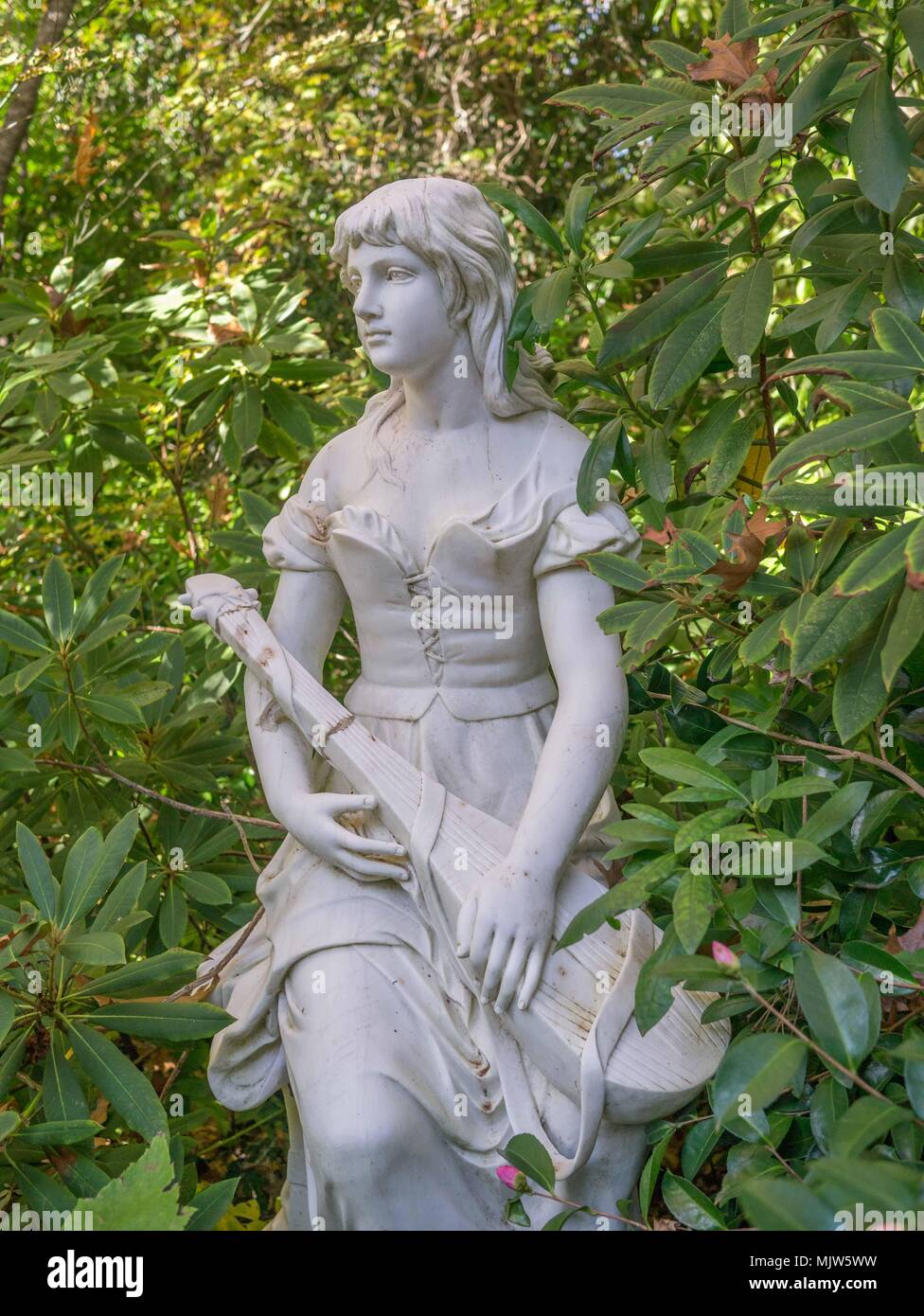 Belle, évocatrice, énergique et bronze statuaire de jardin en pierre dans un jardin formel à Forest Glade Jardins en Mt en Macédonie, l'Australie. Banque D'Images