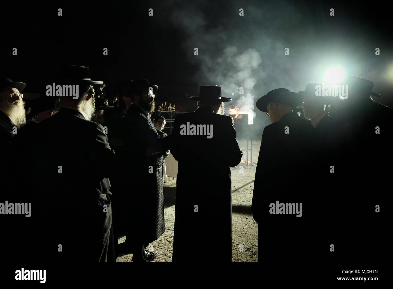 Les hommes juifs ultra-orthodoxes de la dynastie hassidique Shomrei Emounim danse comme ils allument un feu d'huile géant dans le quartier religieux Geula lors de la fête de Lag BaOmer qui marque la célébration, interprétée par certains comme l'anniversaire de la mort de Rabbi Shimon Bar Yochai, un des grands sages du judaïsme, il y a quelque 1800 ans et le jour où il a révélé les secrets de la kabbale un texte historique de la mystique juive Banque D'Images