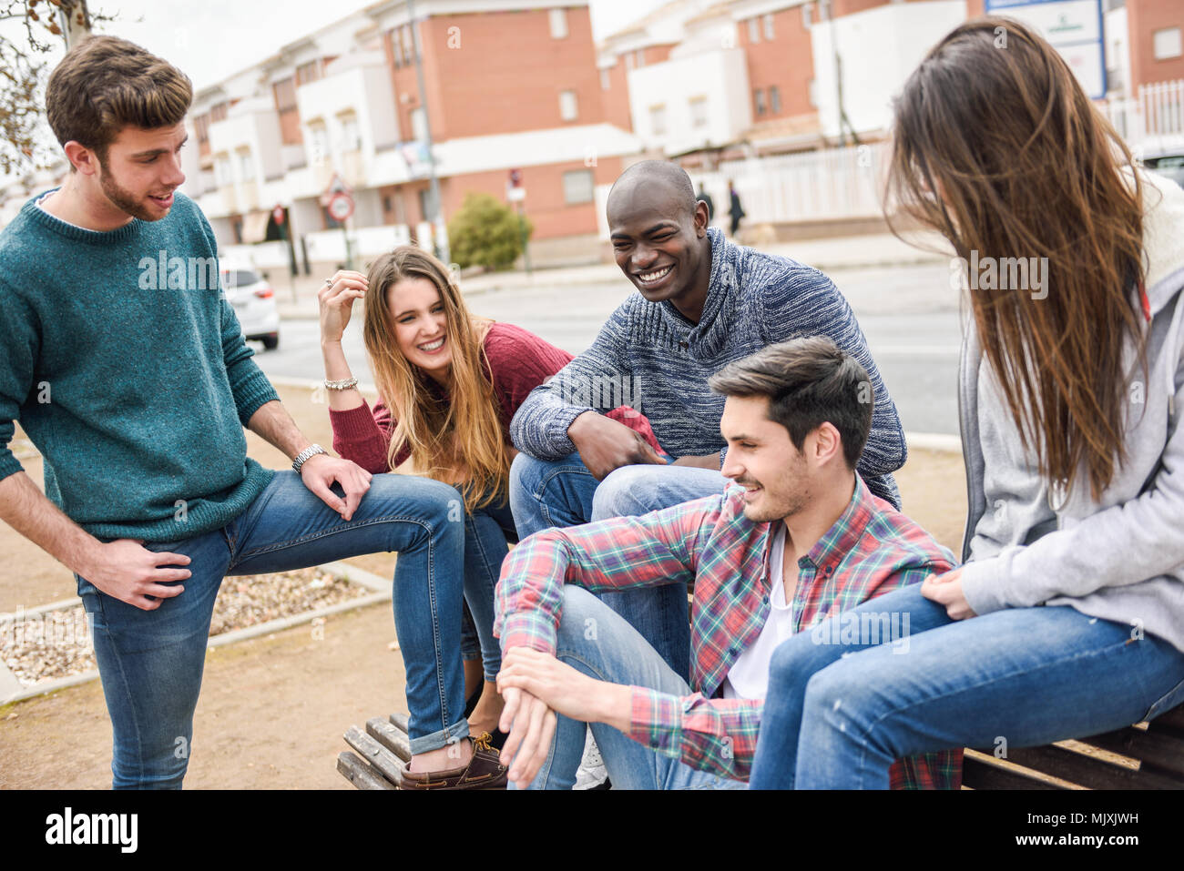 Groupe de jeunes multi-ethnique de s'amuser ensemble en plein air dans l'arrière-plan urbain Banque D'Images