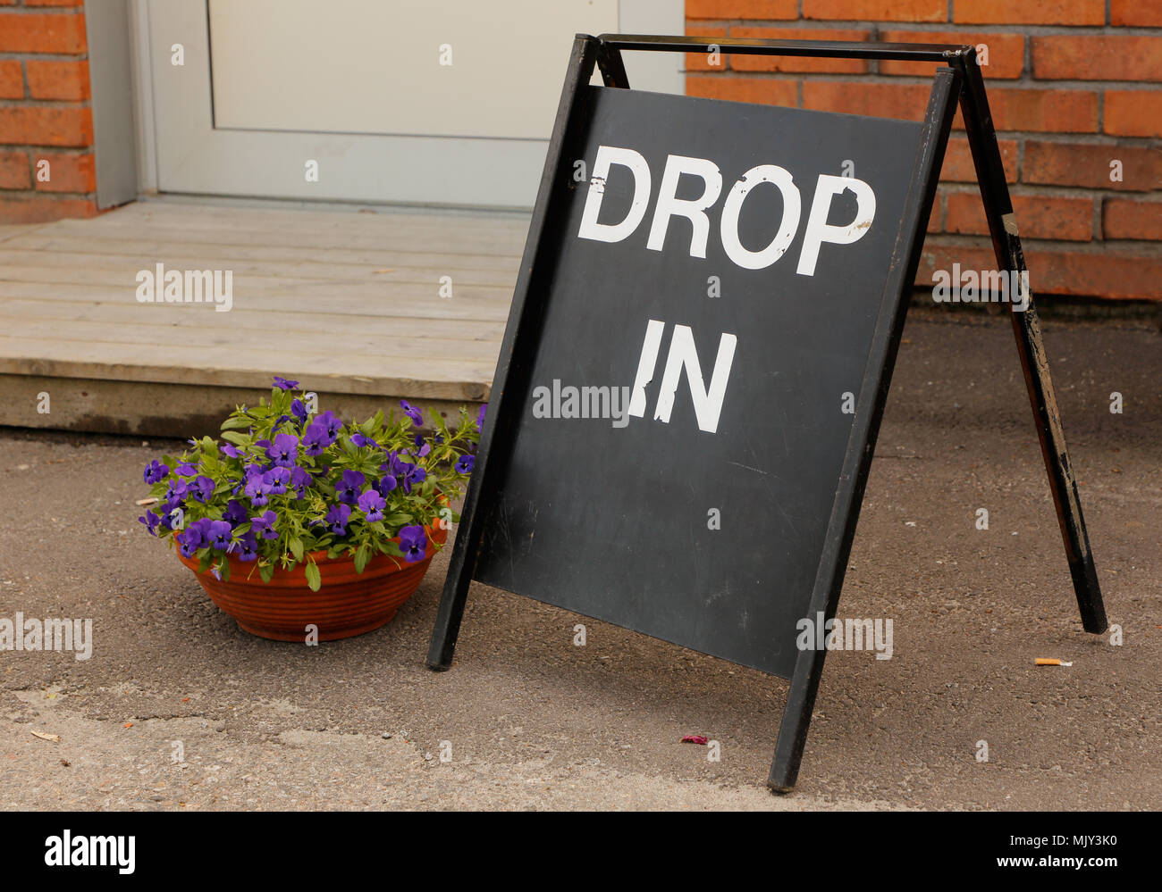 Une chute de signer avec du texte blanc onblack l'extérieur d'un bâtiment. Banque D'Images