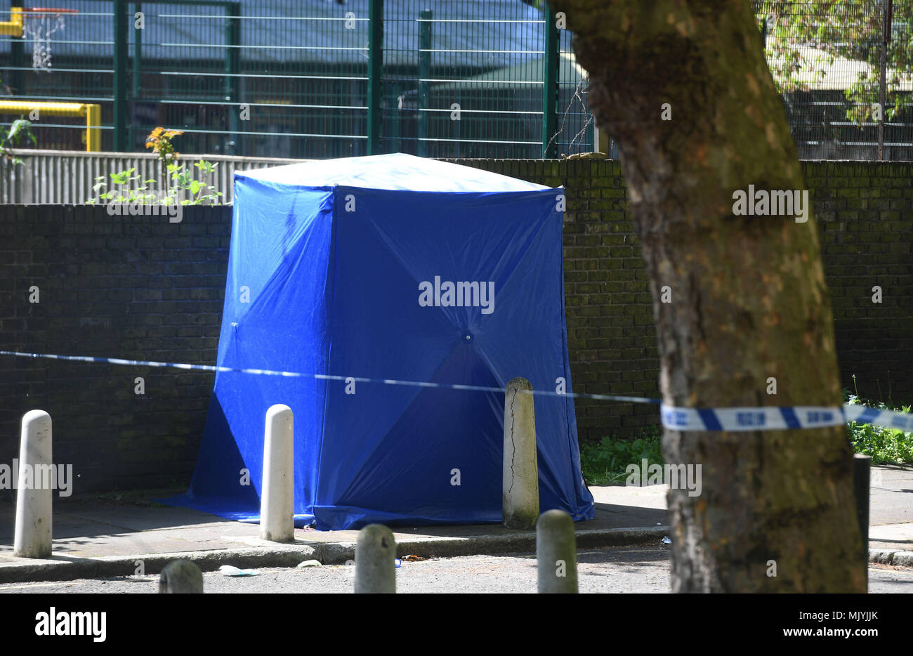 Une expertise médico-légale par la tente bleu cordon de police dans la région de Warham Street, Southwark, Londres du sud, où un garçon de 17 ans a été abattu samedi soir, après qu'ont été appelés à coups de rapports sur la route à proximité de cuisiniers. Banque D'Images