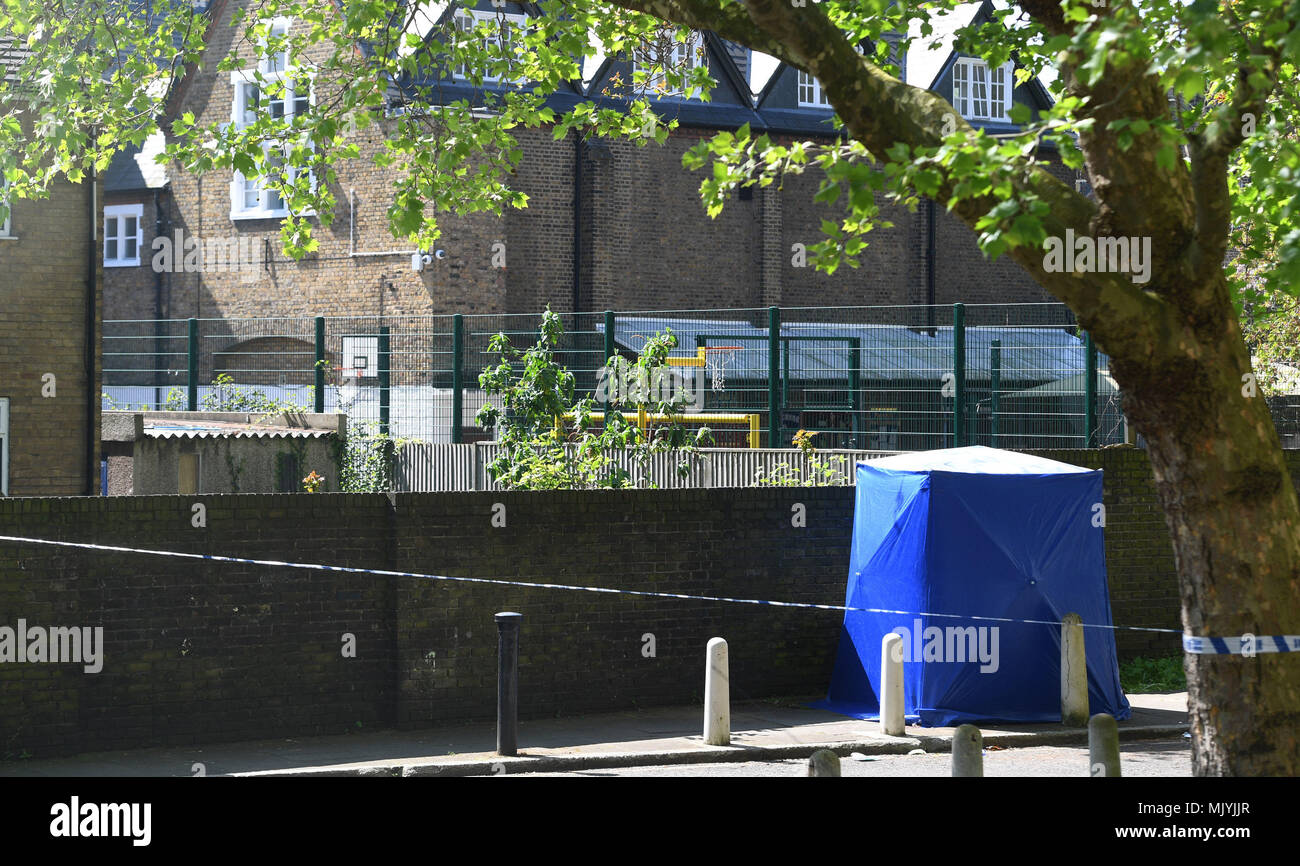 Une expertise médico-légale par la tente bleu cordon de police dans la région de Warham Street, Southwark, Londres du sud, où un garçon de 17 ans a été abattu samedi soir, après qu'ont été appelés à coups de rapports sur la route à proximité de cuisiniers. Banque D'Images