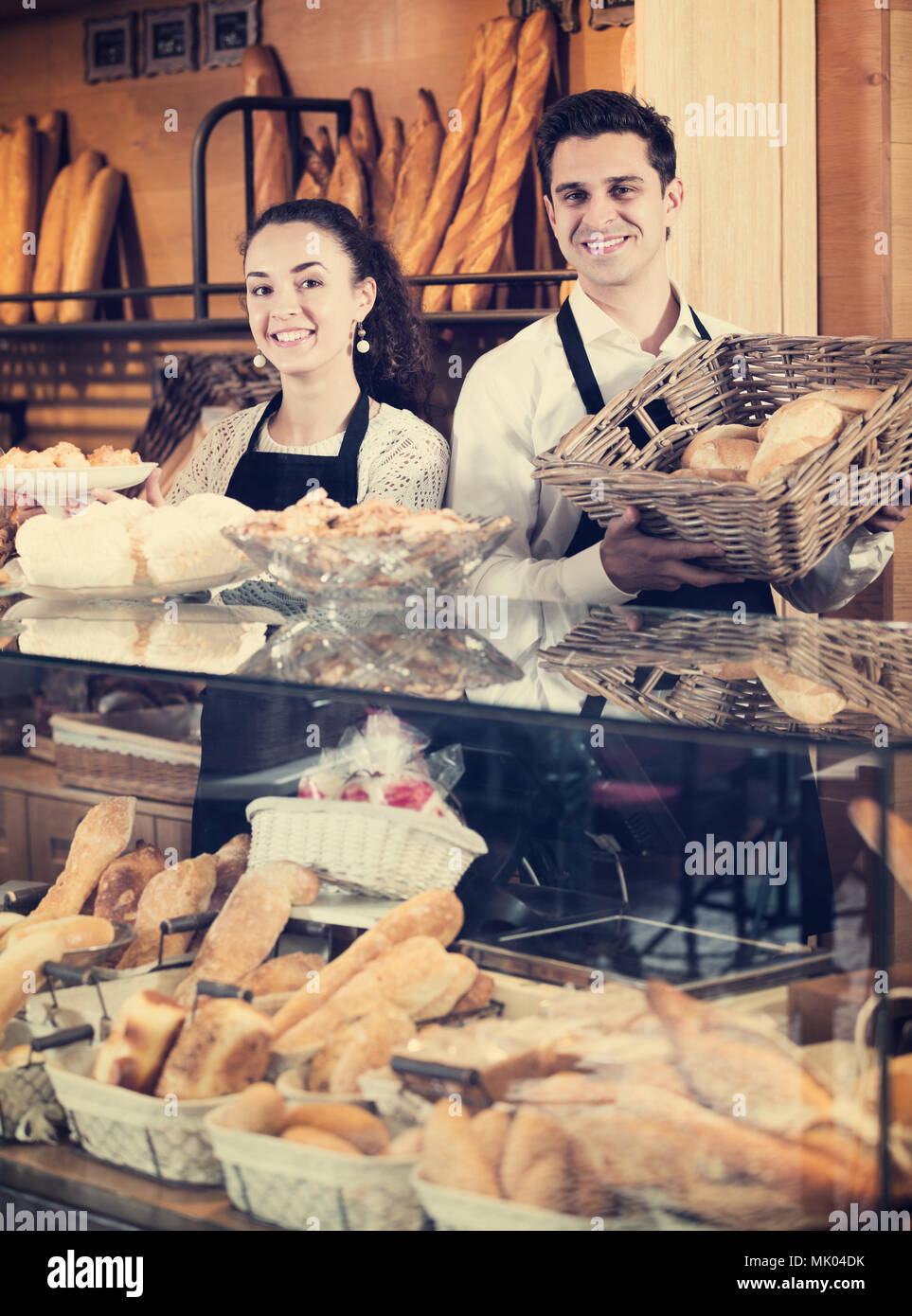 Le personnel vendeur attrayant offrant du pain et pâtisseries différentes à vendre Banque D'Images