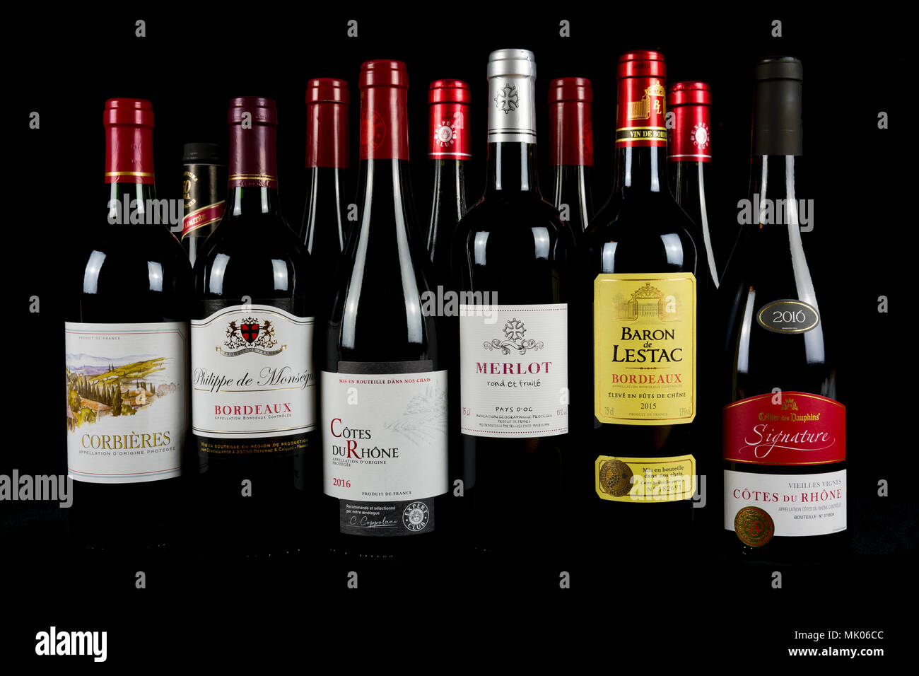 Saint Malo, Bretagne, France - 6 Avril 2018 : une sélection de bouteilles de vin rouge Français fusionnant avec un fond noir Banque D'Images