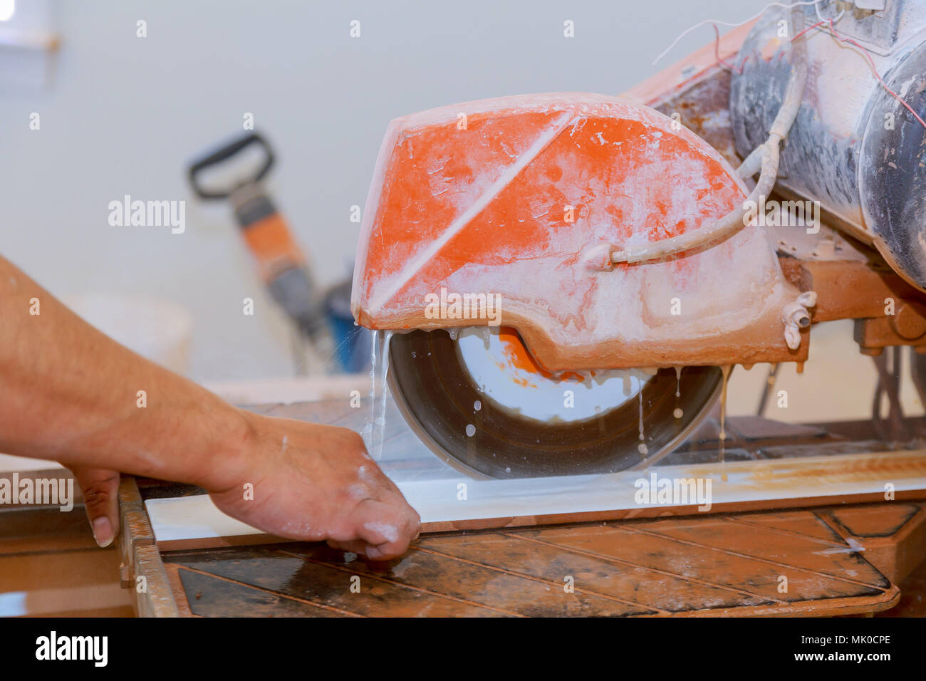 La coupe manuelle des carreaux de céramique sur une machine spéciale pour la coupe de carreaux. Banque D'Images