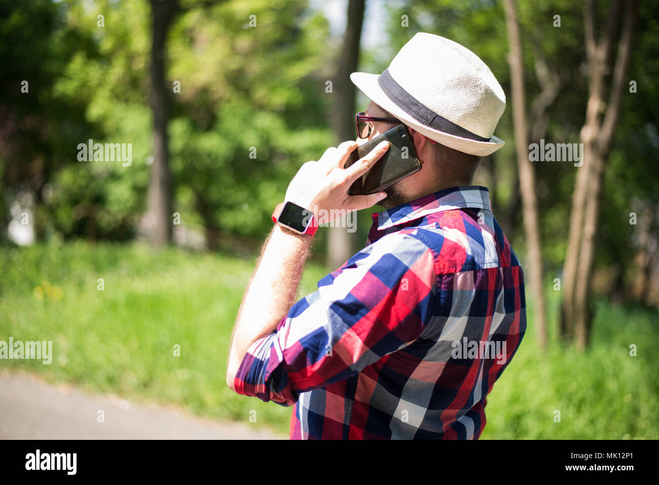 Bucarest, Roumanie, - le 26 octobre, 2017 : Personne à l'aide de smart watch et un smartphone marche sur le parc en un dimanche. Jeune homme faisant des gestes sur un porter Banque D'Images