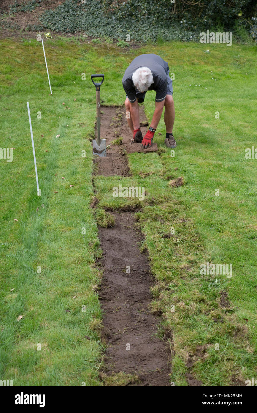 L'homme coupe de gazon glissant trois abeilles pelouse jardin communautaire Avril 2018 Mickleton Cotswolds UK Banque D'Images