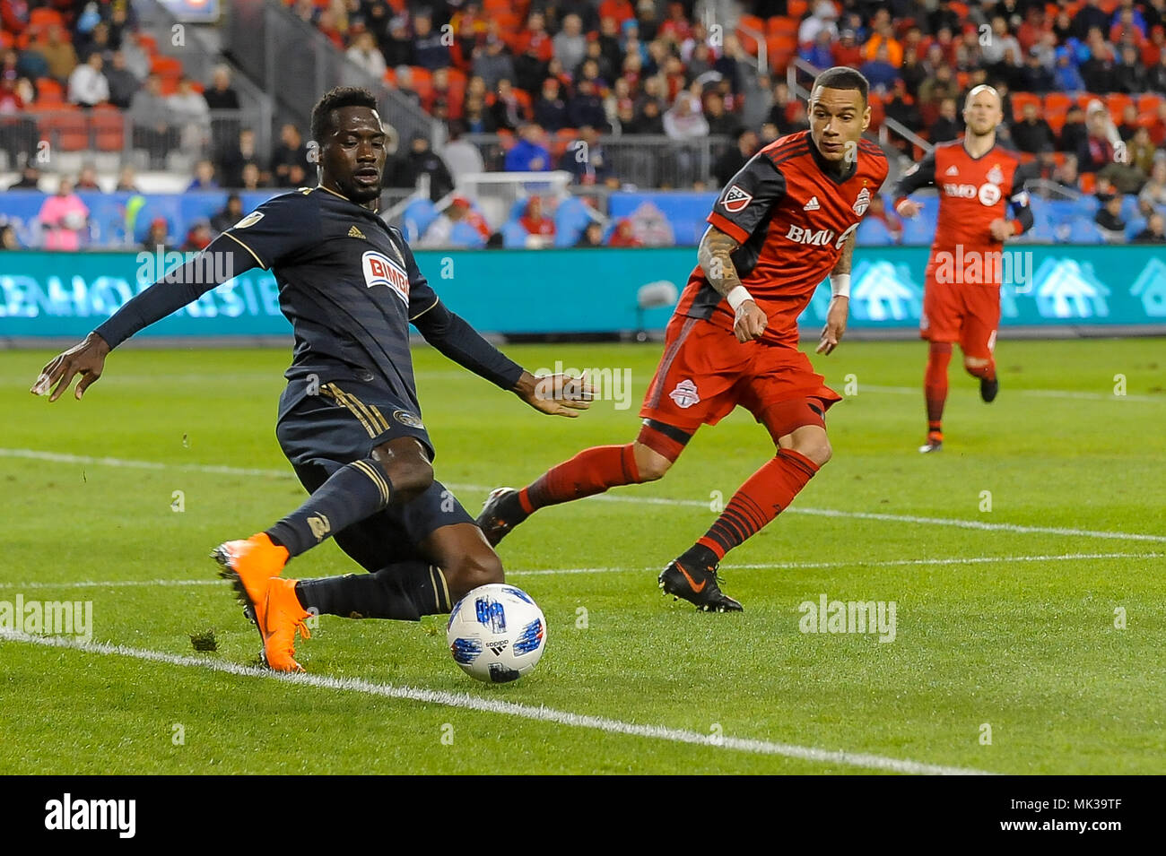 David Accam (L) tente de frapper la balle pendant la saison régulière MLS 2018 match entre FC de Toronto (Canada) et l'Union de Philadelphie (USA) au BMO Field (score 3:0). Banque D'Images