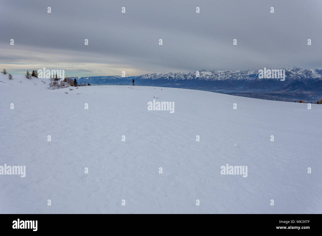 Homme marchant sur la neige, avec les sommets des Dolomites en arrière-plan, le Col Visentin, Padova, Italie Banque D'Images