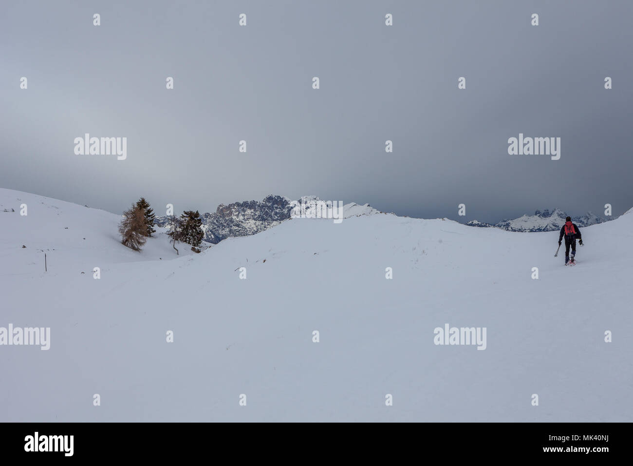 Homme marchant sur la neige, avec les sommets des Dolomites en arrière-plan, le Col Visentin, Padova, Italie Banque D'Images