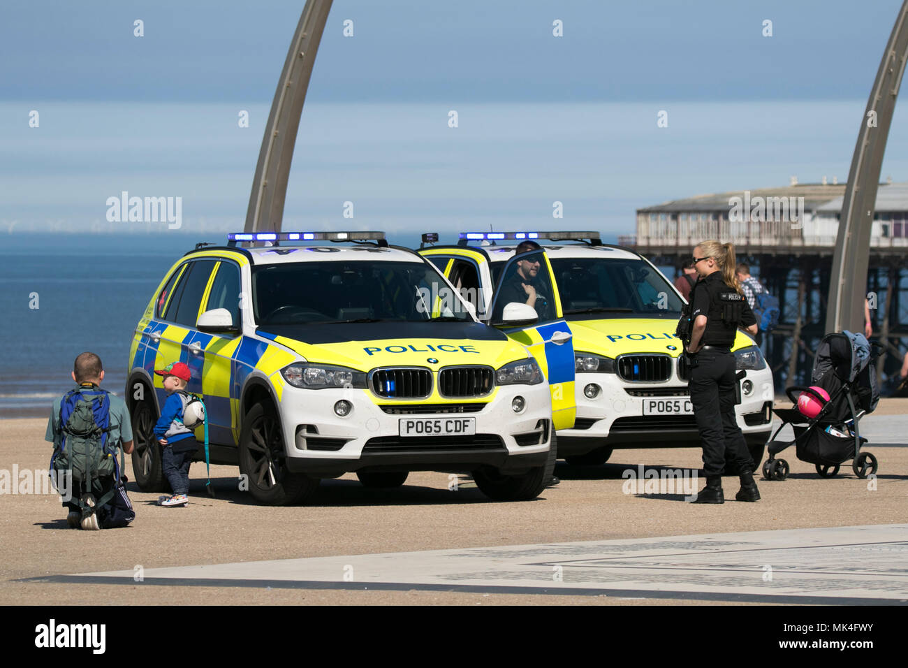 Des policiers armés en interaction avec le grand public sur la promenade sur le front de mer de Blackpool Banque D'Images