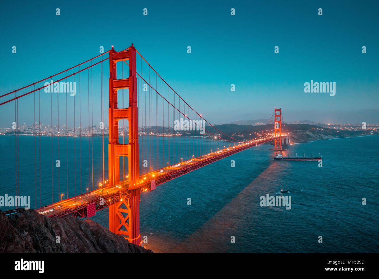 Vue panoramique classique du célèbre Golden Gate avec cargo navire de fret dans le magnifique coucher du soleil au cours de l'après twilight blue hour au crépuscule en été, San Francis Banque D'Images