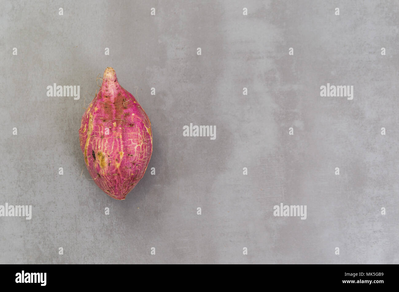 Grand concept de la saine alimentation, la patate douce sur fond gris, béton poli. Banque D'Images