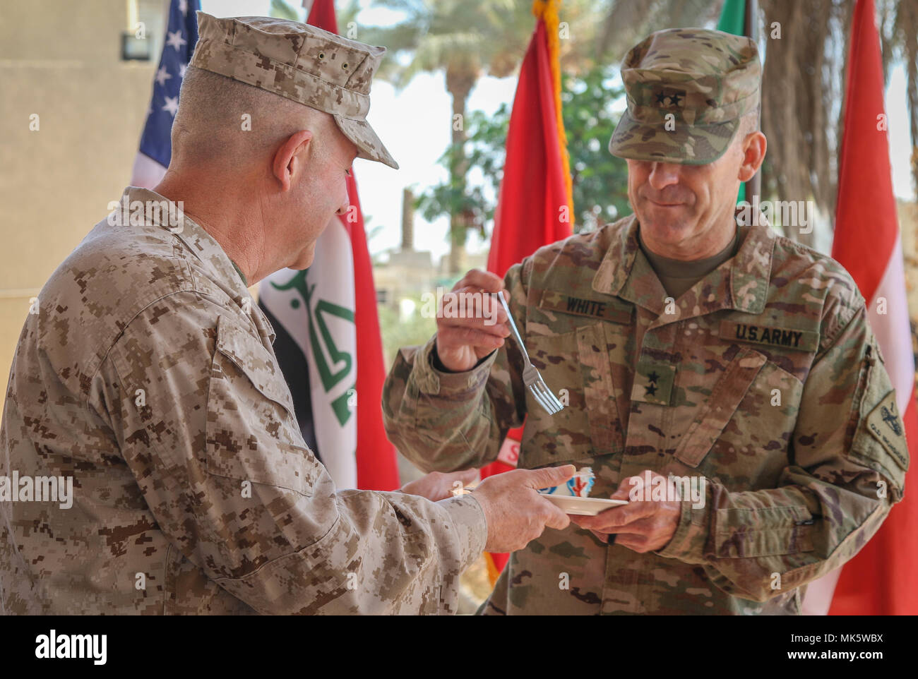 U.S. Marine Brigue. Le général Robert B. Sofge, commandant général adjoint pour les opérations de la composante terrestre des Forces conjointes - Fonctionnement résoudre inhérent, sert une tranche de gâteau au major général Pat White, commandant général du CJFLCC-OIR et 1st Armored Division et de Fort Bliss, Texas, au cours de la 242e cérémonie d'anniversaire du Corps des Marines à Bagdad, l'Iraq, le 10 novembre 2017. (Photo par le Sgt. Von Marie Donato) Banque D'Images