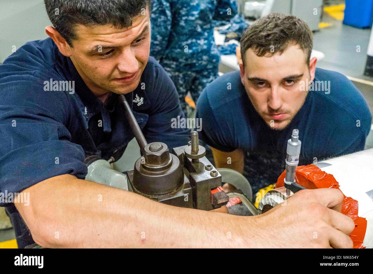 Réparateur de machines 2e classe Bryan Dixon et électricien, d'officier de 3e classe Jordanie Vermette, les deux marins affectés à l'adjudication du sous-marin USS Emory S. Land (comme 39), mesurer l'écart entre une pompe d'amorçage pour l'Ohio-classe de sous-marins lance-missiles USS Michigan (SSGN 727). L'Emory S. Land, homeported à Guam, offre des services de maintenance, les services de l'hôtel et un soutien logistique à des sous-marins et navires de surface aux États-Unis 5e et 7e flotte secteurs d'opérations. (U.S. Photo par marine Spécialiste de la communication de masse 3e classe Daniel Willoughby/libérés) Banque D'Images