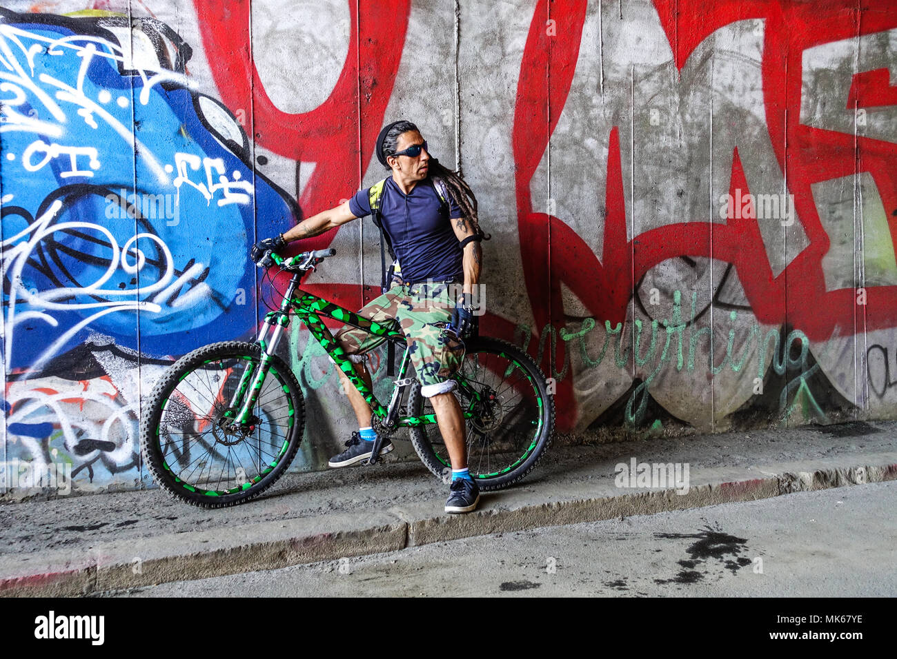 Homme vélo ville rue graffiti, motard, cycliste au mur urbain, Tesnov, Prague, Ceska Republika Banque D'Images