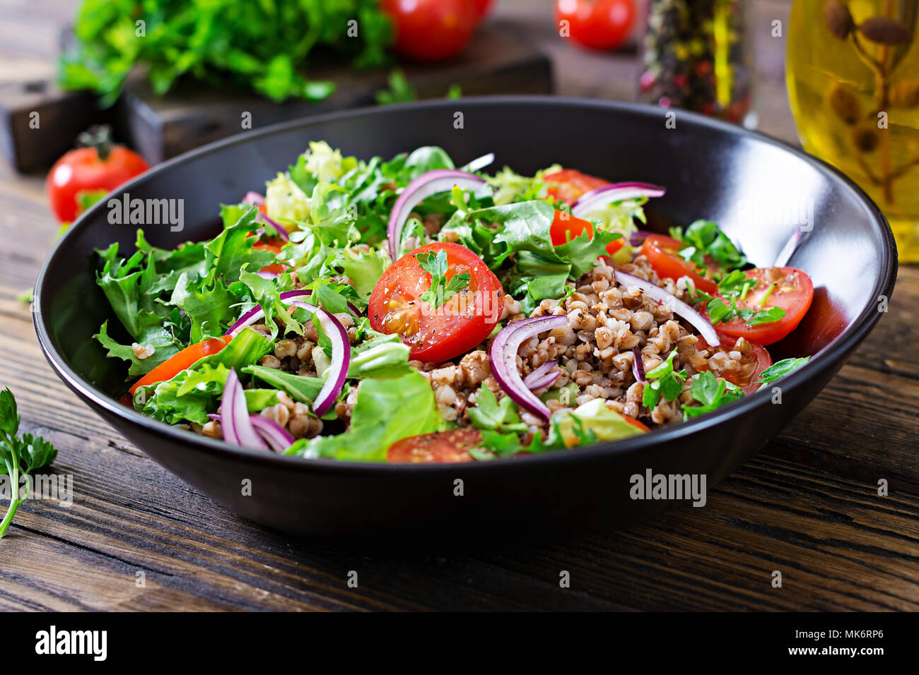 Salade de sarrasin avec tomates cerises, l'oignon rouge et d'herbes fraîches. La nourriture végétalienne. Menu de régime. Banque D'Images