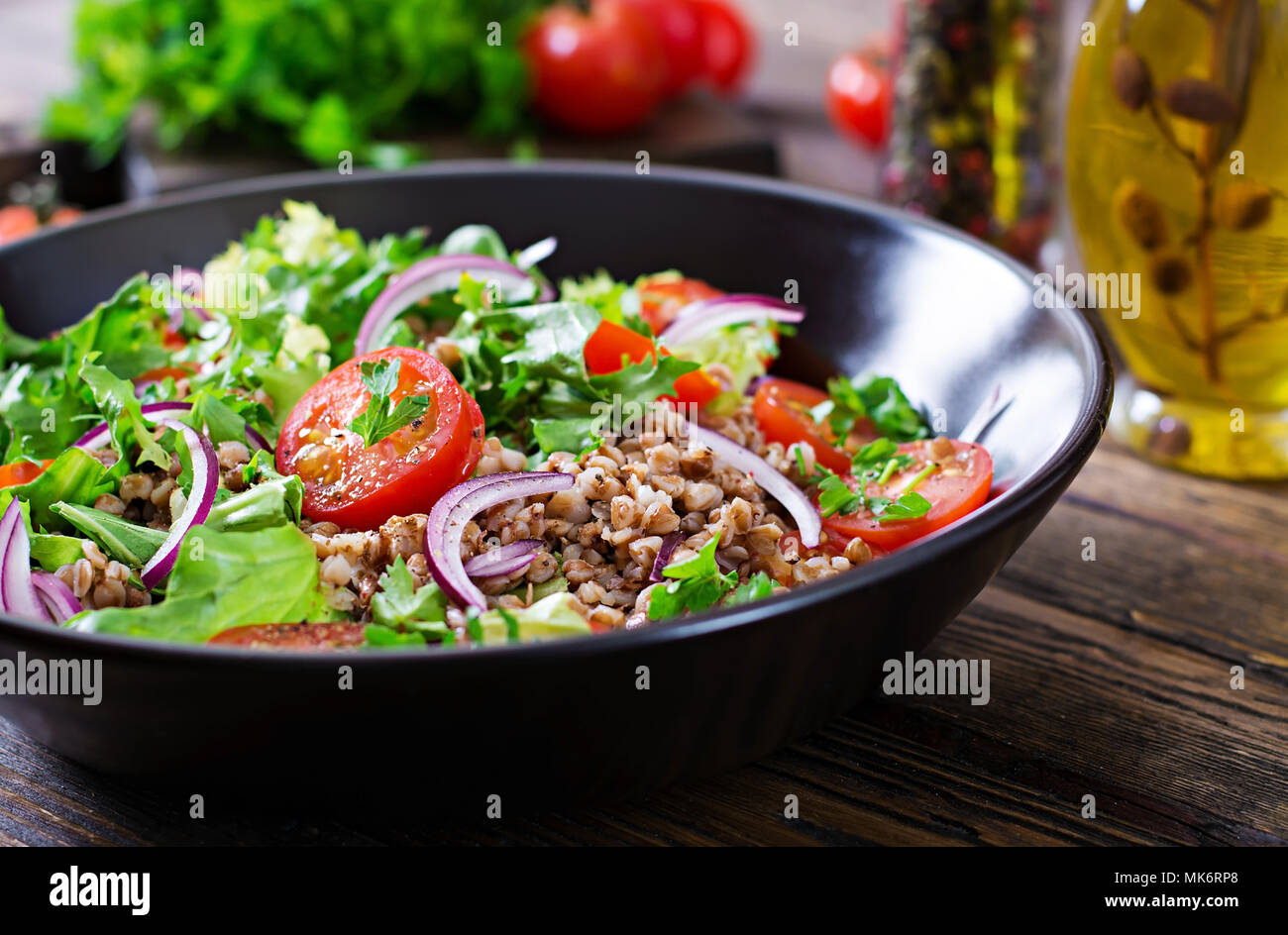 Salade de sarrasin avec tomates cerises, l'oignon rouge et d'herbes fraîches. La nourriture végétalienne. Menu de régime. Banque D'Images