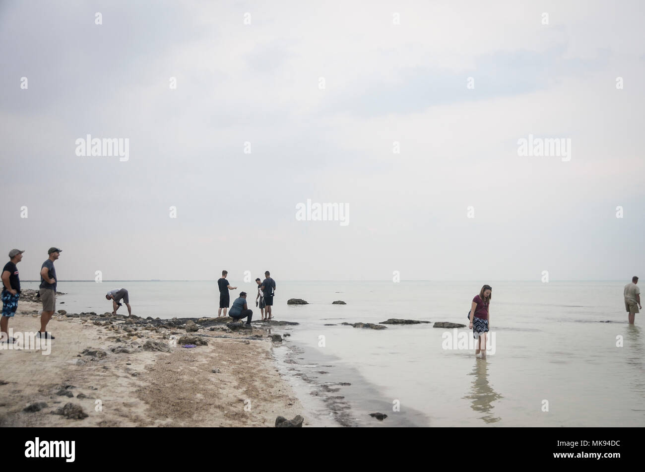 Les aviateurs américains déployés à Al Udeid Air Base, Qatar, vous détendre et patauger dans l'eau après un après-midi de faire du bénévolat dans un cas de nettoyage des plages à Al Jemaal Beach au Qatar, le 19 novembre 2017. Les aviateurs s'est associé à des actions environnementales à Doha Projet ramassent les déchets à l'UNESCO-protected, ancien village de pêcheurs dans le nord du Qatar. (U.S. Photo de la Garde nationale aérienne par Slt Jenna Lenski) Banque D'Images