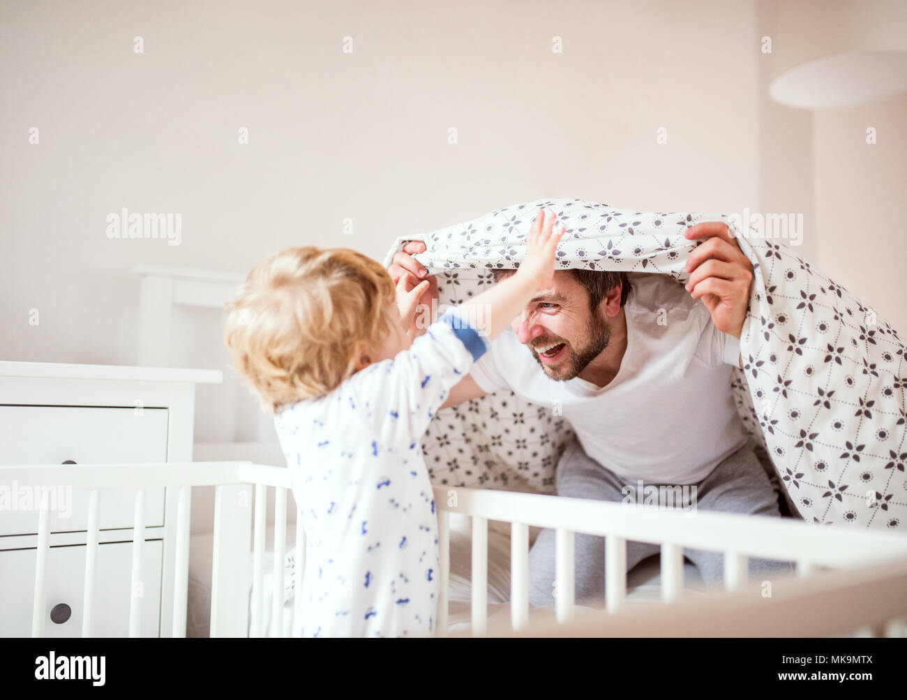 Père avec un bébé garçon s'amuser dans la chambre à la maison au coucher. Banque D'Images