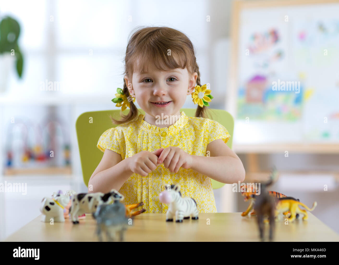 Enfant jouant avec des jouets au tableau à la maternelle ou à la maison Banque D'Images