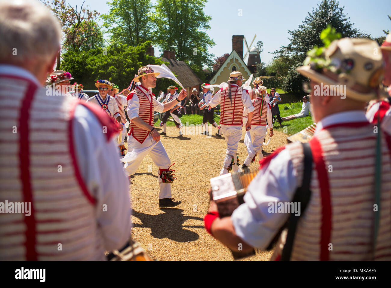 Thaxted Essex England UK. Banque de jours de mai Maison de vacances lundi 7 mai 2018 sur l'un des plus chauds peuvent jour lundis fériés jamais enregistré la Thaxted Morris à rayures rouges et blanches et les Blackmore Morris en bleu du côté de la danse dans la région de Chelmsford Bull Ring en face de Thaxted Église et les maisons l'Aumône Thaxted pour célébrer les vacances de mai. Crédit : BRIAN HARRIS/Alamy Live News Banque D'Images