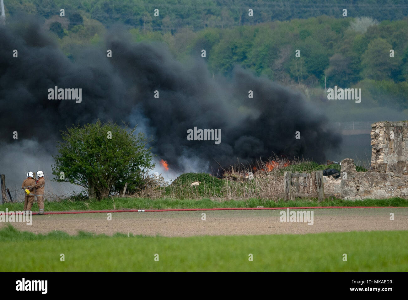 Airth en Ecosse, Royaume-Uni. 7 mai, 2018. 2 pompiers à la sur-pupilles vers le brasier. Les pompiers ont été appelé pour faire face à un incendie dans l'Airth, Falkirk. 3 camions et 5 à 8 pompiers présents sur scène. La police a la route jusqu'à qu'elle est fermée. Credit : SOPA/Alamy Images Limited Live News Banque D'Images